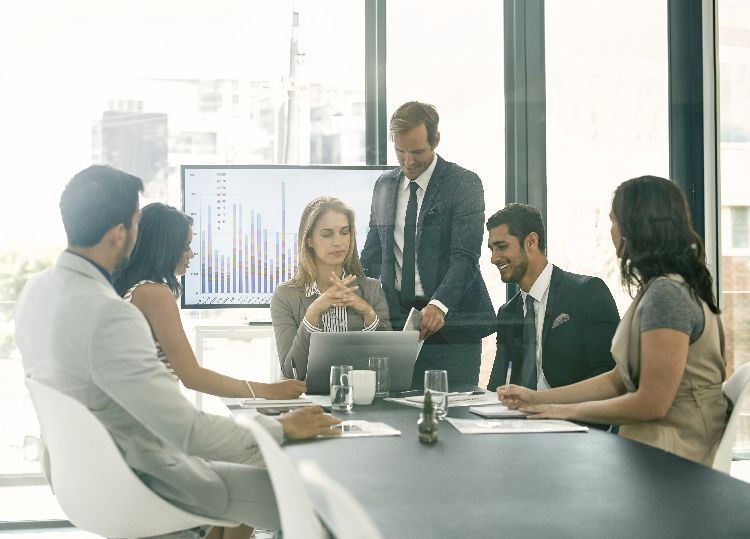 Executive team meeting or presentation discussing strategies and building sales and marketing momentum.